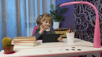 Child girl doing school homework, using digital tablet computer at home. Back to school, online learning, distance lesson, pupil education at home, technology for schoolgirl. Slow motion, 6k downscale video