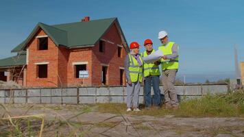 Architect with senior civil engineers discussing project work with blueprint of building house. Construction contractor working on a construction site of apartment. Discussing planning, development video