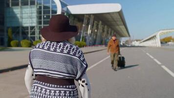 Elderly old grandmother grandfather retirees tourists reunion in airport terminal or railway station after traveling. Lovely senior couple husband and wife happily hugging meeting after business trip video