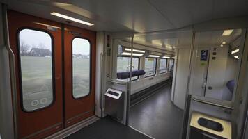 Modern interior of a Swiss double-decker train shows the first floor with standing space, toilet access, and wide windows for scenic views. Functional design ensures passenger comfort and mobility. video
