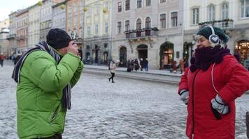 elegante mayor mayor Pareja turistas abuela y abuelo de viaje, tomando foto imágenes en retro cámara en invierno ciudad calle. encantador maduro pensionistas familia vacaciones Navidad Días festivos video