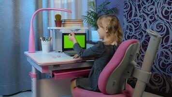 Preschool child girl distance online learning at home. Pupil kid listening audio lesson studying at table using digital laptop computer doing homework. Children remote education on covid-19 quarantine video