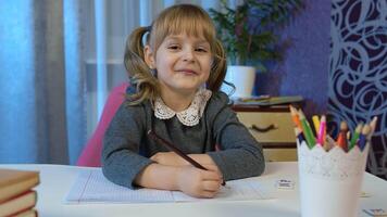 Child girl looking at web camera making call learning, studying lessons at home, showing thumb up. Online pupil distance internet education lesson for children kids during coronavirus lockdown video