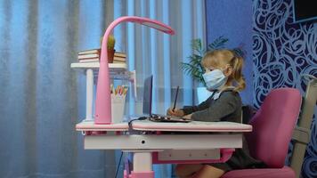 Child girl in mask doing school homework with teacher, using laptop computer at home. call by webcam on internet. Online e-learning, children pupil distance education lesson, technology for kids video
