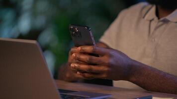 africano americano o negócio homem mãos segurando Móvel telefone rolagem gadget conectados trabalhos homem de negocios dentro escritório noite tarde masculino Empregador Smartphone mensagem Internet rede rede usando aplicativo cortada Visão video
