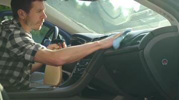 Man cleans car dashboard with microfiber cloth and spray bottle video