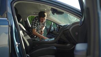 Man cleaning car dashboard with microfiber cloth and spray bottle video