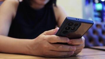 woman using smartphone in a cafe. close-up. focus on hands and phone, blurred background. concept of technology, communication, and modern lifestyle video