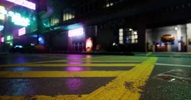 CGI Vibrant urban street with neon lights reflected in wet pavement at night video