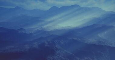 CGI Mountain landscape with soft blue hues and light rays illuminating valleys video