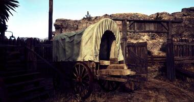 CGI Old wagon at a rustic wooden gate in a desert setting during daylight hours video