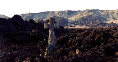 CGI Ancient stone cross standing amid rugged terrain with distant mountains video