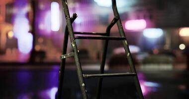 CGI Ladder stands in the foreground with vibrant city lights in the background video