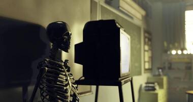 CGI Skeleton sits beside a television in a classroom environment at night video
