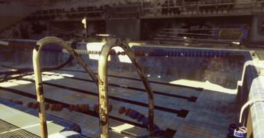 CGI Old swimming pool with rusted ladder and sunlight shining on the tiles video