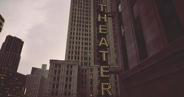 CGI Bright lights adorn a theater building during twilight in a bustling city video