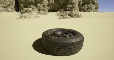 CGI Abandoned tire on sandy terrain near rocky formations under clear sky video