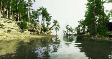 CGI Serene lakeside view with rocky shorelines and lush greenery during daytime video