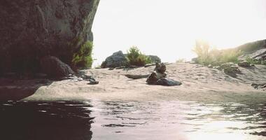 CGI Serene beach landscape at sunset with reflective water and rocks video