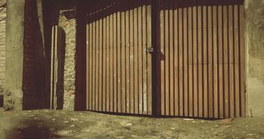 CGI Old wooden gates in a rustic alley with stone walls during daylight video