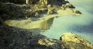 CGI Coastal view of sandy beach and rocks in bright sunlight video