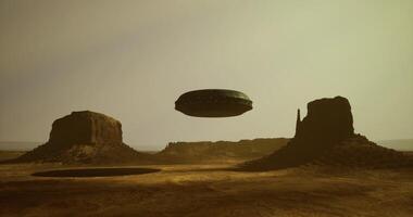 CGI Mysterious UFO hovers above desert landscape with rock formations at dusk video