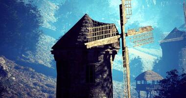 CGI Historic windmill stands against a serene mountain backdrop during daylight video