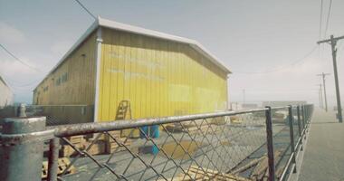 CGI Bright yellow building surrounded by fence in an industrial area in daylight video