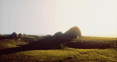 CGI Mysterious stone structure casting a long shadow on grassy landscape at sunset video