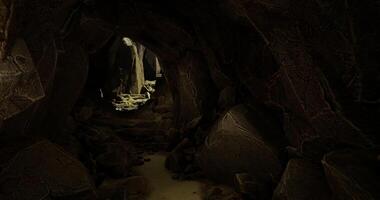 CGI Exploring a dark cavern with mossy rocks and glowing light in the distance video