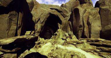 CGI Rocky cave entrance with flowing water and natural formations in bright light video