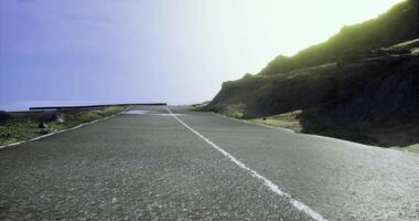 CGI Scenic coastal road surrounded by cliffs and bright sky at sunset video