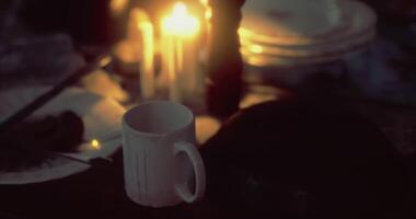 CGI Candlelit table setting with mug surrounded by dim lighting and dishes video