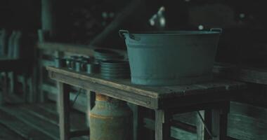 CGI Old wooden table with metallic bucket and utensils in a dimly lit setting video