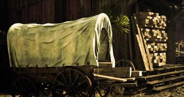 CGI Wagon with a canvas cover beside stacks of wood in a rustic setting video