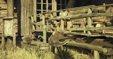 CGI Rustic saddle resting on wooden railing near an old western building video