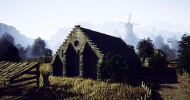 CGI Old stone building surrounded by wheat fields and distant windmill at dawn video