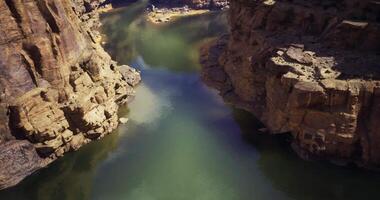 CGI Canyon river flows through rocky landscape under bright blue sky video