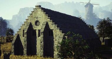 CGI Historic stone building surrounded by nature with a windmill in the background video