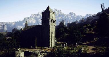 CGI Ancient stone church beside mountains and windmills during daylight video
