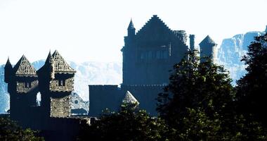 CGI Ancient castle silhouette rising against mountains at dawn video