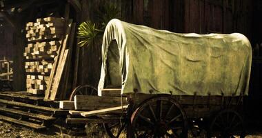 CGI Rustic wooden wagon covered with canvas near lumber stacks at a farm video