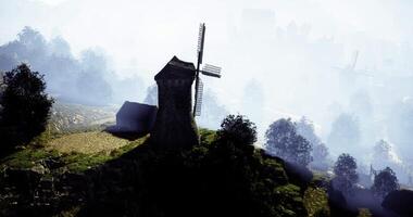 CGI Windmill stands atop a hill surrounded by fog on a peaceful morning video