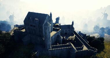 CGI Imposing medieval castle surrounded by misty hills and windmills video