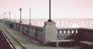 CGI Quiet waterfront promenade with vintage lampposts and distant bridge at dawn video
