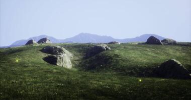 CGI Rolling green hills under a bright sky with distant mountains in view video