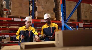 Two warehouse workers are reviewing the list of items based on the documentation,151 photo