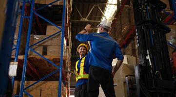 A bunch of warehouse workers are reviewing the list of items based on the documentation,149 photo