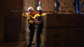 Two warehouse workers are reviewing the list of items based on the documentation,140 photo