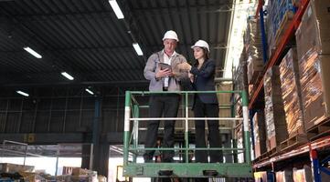 Business woman and warehouse workers are reviewing the list of items based on the documentation,127 photo